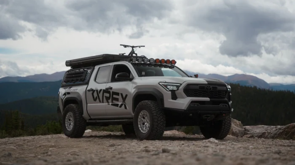Toyota Tacoma with aftermarket lighting on off-road terrain