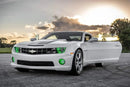 Three quarters view of a Chevrolet Camaro with green LED headlight and fog light halo rings installed.
