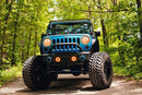 Front end of a Jeep Wrangler JK with amber LED headlight and fog light halos installed.