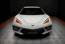 Front view of a white C8 Corvette with amber headlight DRLs.