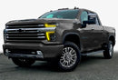 Three quarters view of a Chevy Silverado with yellow headlight DRLs.