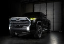 Three quarters view of a black Toyota Tundra with yellow demon eye projectors.