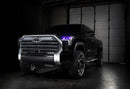Three quarters view of a black Toyota Tundra with purple demon eye projectors.