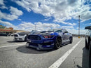 Three quarters view of a Ford Mustang with red headlight halos and DRLs.