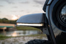 Side view of a vehicle with a light bar against a blurred natural background