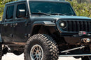 Black Jeep Wrangler with off-road tires on a natural background
