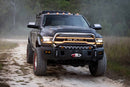 Black Ram truck driving on a dirt road in a forested area