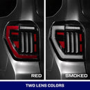 Two car tail lights, one red and one smoked, on a dark background.