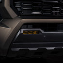 Close-up of a vehicle grille with a prominent hexagonal design and an unlit LED fog light.