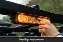 Hand adjusting a amber LED light bar on a vehicle with 'SmartTap Programming' from Diode Dynamics.