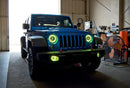 Three quarters view of a Jeep Wrangler with yellow LED headlight and fog light halos installed.