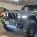 Jeep parked in a garage with multiple lighting products installed and turned on.
