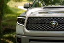 A photo of a grey Toyota Tundra with a Morimoto headlight on it.