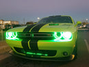 Front end of a Dodge Challenger with green LED headlight halo rings installed.