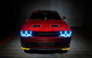Front view of a red Dodge Challenger with cyan LED headlight halo rings installed.