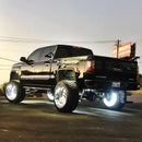 Rear three quarters view of a black GMC Sierra with white LED wheel rings.