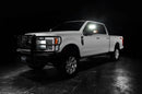 Three quarters view of a white Ford SuperDuty with LED Off-Road Side Mirrors turned on.