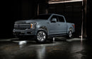 Grey Ford F-150 with white wheel rings and rock lights.