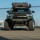 Front view of a Green Toyota 4Runner with additional lights and an RTS “Rugged Terrain Series” Front Winch Bumper (2014-2024 models) on a paved surface.