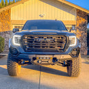Front view of a GMC Sierra 1500 (2019-2021 models) with an RTS “Rugged Terrain Series” Front Winch Bumper parked in a residential driveway in front of a garage.