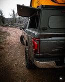 Gray Ford F-150 with an open cargo area on a dirt road