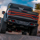 Rear view of a Jeep Gladiator JT, with multiple LED lighting products installed, including Flush Mount Tail Lights, High Powered Reverse Lights and Racetrack LED Tailgate Panel.