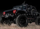 Three quarters view of a Jeep Wrangler JK with red LED headlight halo rings installed.