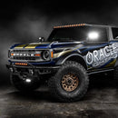 Three quarters view of ORACLE Lighting wrapped Ford Bronco with Integrated Windshield Roof LED Light Bar System installed and set to amber LEDs.