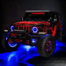 Three quarters view of a red Jeep Wrangler JL with High Performance 20W LED Fog Lights installed, and blue halos on.