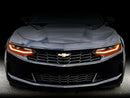 Front end of a Chevrolet Camaro with amber headlight DRLs.