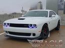 Three quarters view of a white Dodge Challenger with white LED headlight and fog light halo rings installed.