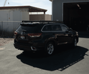 Black Toyota highlander parked in a lot with a building in the background mounted with a Prinsu Roof rack.