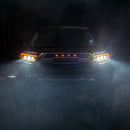 Front view of a Toyota truck in a dark, foggy environment