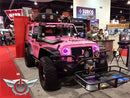 Pink Jeep in a showroom with pink LED headlight halo rings installed.