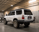 White 4Runner with a prinsu roof rack in a warehouse setting